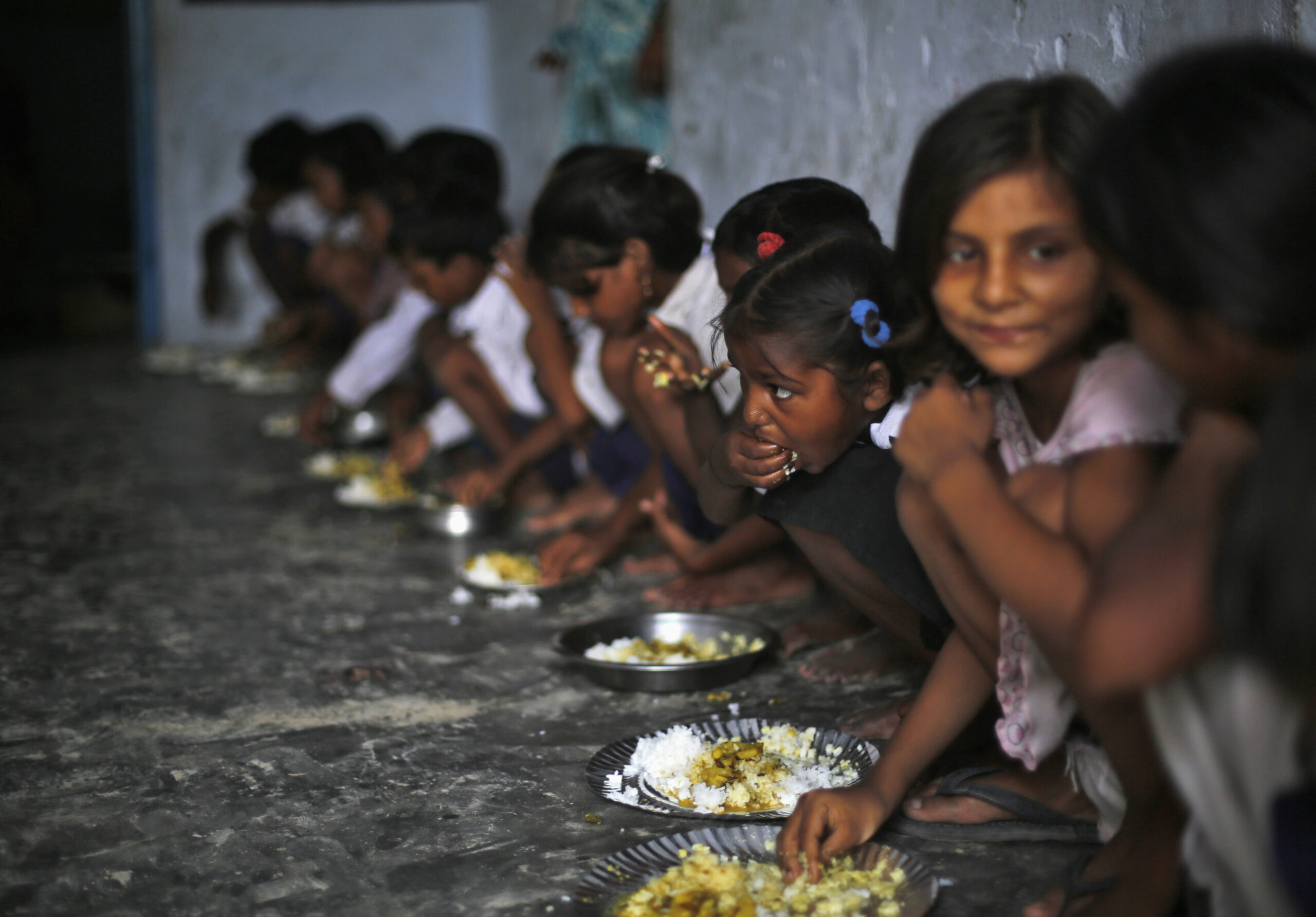 School children eat their free mid-day meal, distributed by a government-run primary school, at Brahimpur village in Chapra district of the eastern Indian state of Bihar July 19, 2013. Police suspect that India's worst outbreak of mass food poisoning in years was caused by cooking oil that had been kept in a container previously used to store pesticide, the magistrate overseeing the investigation said on Friday. REUTERS/Adnan Abidi (INDIA - Tags: DISASTER HEALTH FOOD EDUCATION TPX IMAGES OF THE DAY) - RTX11RYS
